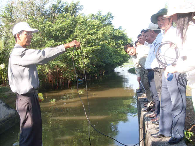 Cán bộ Trung tâm quan trắc môi trường Hậu Giang đang tiến hành đo độ mặn trên một nhánh sông