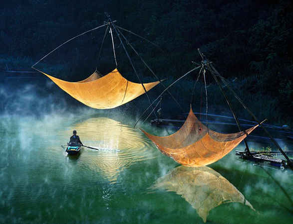 Ngư dân Việt Nam kiểm tra lưới của họ. Kinh tế biển là một trong những ngành kinh tế mạnh của Việt Nam, với mục tiêu phấn đấu đạt 53-55% GDP vào năm 2020 và chiếm hơn 60% kim ngạch xuất khẩu của cả nước. Tuy nhiên, đánh bắt quá mức đang thực sự là mối lo ngại lớn khi khu vực Đồng bằng sông Cửu Long, nơi có hàng triệu người sinh sống, đang phát triển mà không có cá khai thác. Ảnh: Hoàng Long Lý