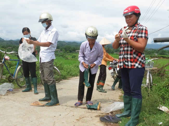 Người dân xã Báo Đáp đeo ủng và gang tay do Sở TN&MT tỉnh Yên Bái phát trước khi ra quân thu gom bao gói thuốc BVTV.