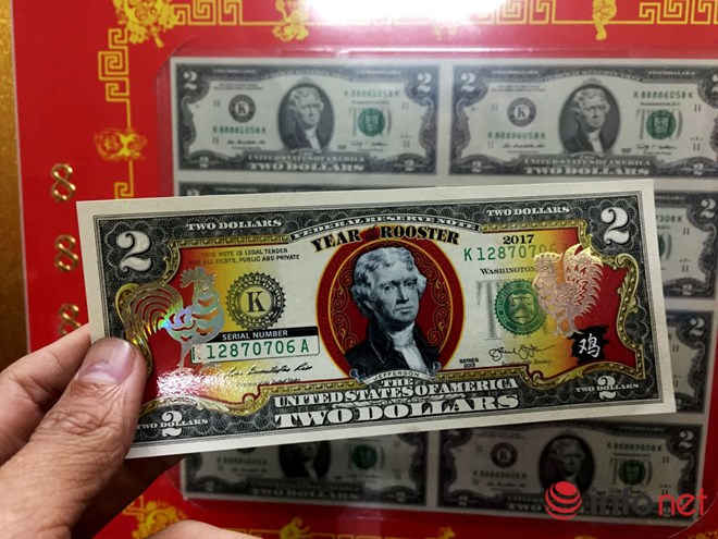 Tờ tiền mệnh giá 2 USD này là tiền thật được phun màu, chế tác hình con gà bán với giá 400 ngàn đồng. Loại tiền tương tự có mệnh giá 1 USD bán giá 350 ngàn/tờ. Chủ điểm bán cho biết loại 1 USD chưa nhập về kịp do qua tết dương lịch 2017 phía Mỹ mới sản xuất. 