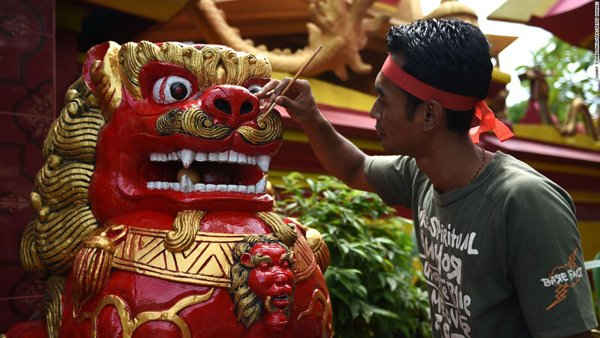 Công nhân sơn bức tượng tại một ngôi chùa ở Denpasar, Indonesia.