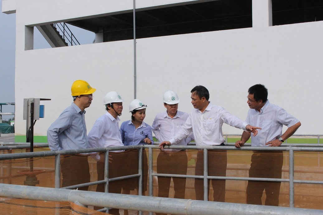 Thứ trưởng Võ Tuấn Nhân và Phó Chủ tịch UBND tỉnh Hậu Giang nghe cán bộ báo cáo chi tiết việc thực hiện các hạng mục xử lý chất thải bảo vệ môi trường tại thực địa trong Nhà máy giấy Lee&Man.