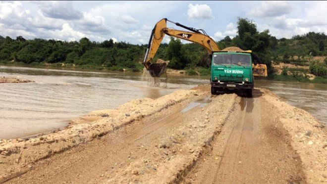Máy móc của doanh nghiệp Trí Thành đang đắp đập. (Ảnh: Cao Nguyên/TTXVN)