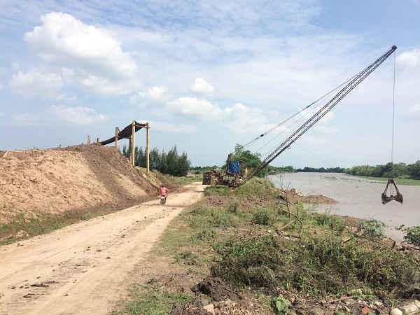 Bãi tập kết nguyên liệu và trụ cẩu điện lấn chiếm mặt đê của Nhà máy gạch Kim Chính