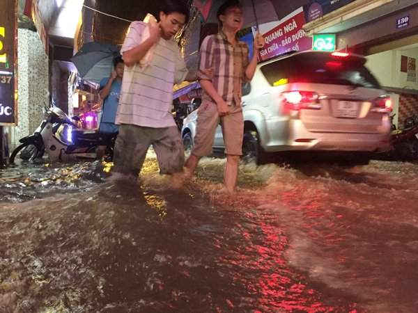 Người dân chọn cách đi bộ lưu thông qua quãng đường ngập lụt