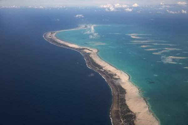 Hình ảnh về đảo Nam Tarawa và trẻ em chơi đùa với những chiếc thuyền đi qua trên đường Nippon – con đường nối liền Betio với phần còn lại của Nam Tarawa. Ảnh: Mike Bowers