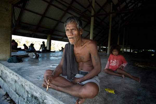 Một người dân làng Tebuginako, đảo Abaiang nhìn xa xăm từ ngôi làng maneaba; trẻ em tại làng Nanikai ở Nam Tarawa nhào lộn trên bãi biển