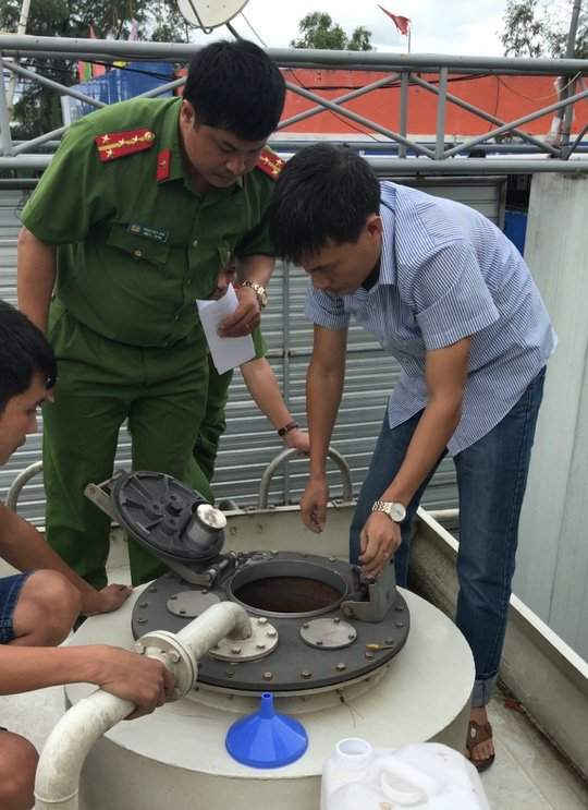 Cơ quan chức năng lấy mẫu kiểm tra xe bồn chở dung môi dùng để pha chế vào xăng.
