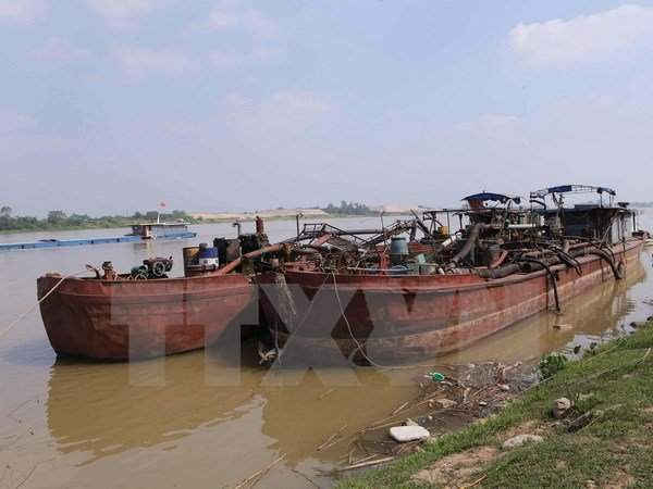 Bắt giữ phương tiện khai thác cát trái phép trên sông Đồng Nai. Ảnh: TTXVN