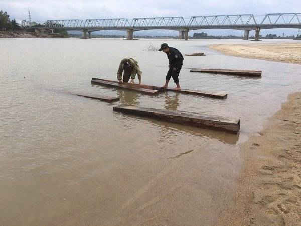 Số gỗ chìm dưới sông Thu Bồn được trục vớt lên bờ.
