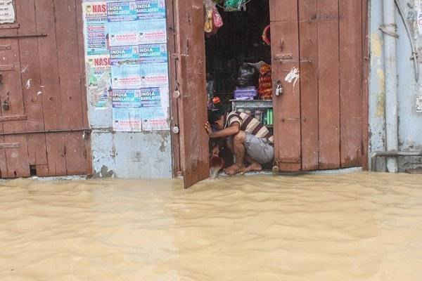 Người bán hàng múc nước từ nhà của ông để cứu hàng hóa.