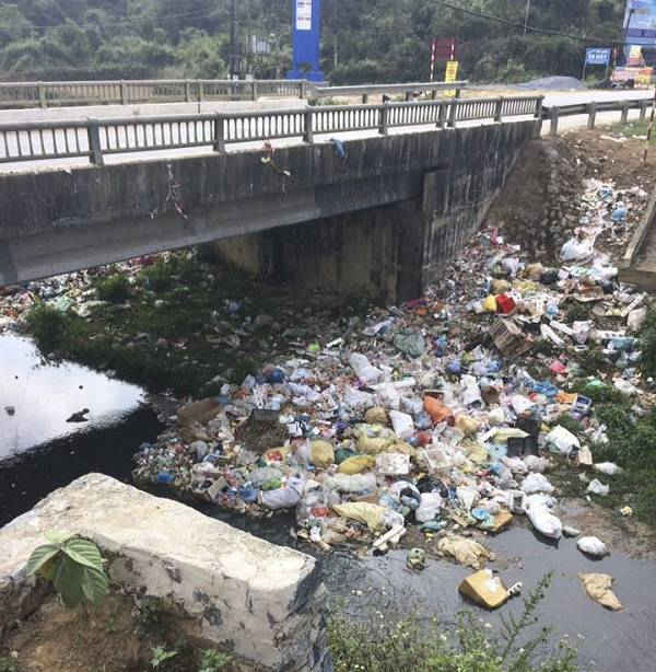 Rác thải nông thôn hiện đang là bài toán khó trong thực hiện tiêu chí số 17 về môi trường xây dựng NTM. Trong ảnh: rác thải ngập chân cầu Nà Tấu, xã Nà Tấu, huyện Điện Biên