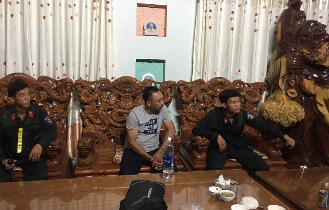 Phượng “râu” mặc áo thun xám ngồi giữa đang làm việc với cơ quan chức năng