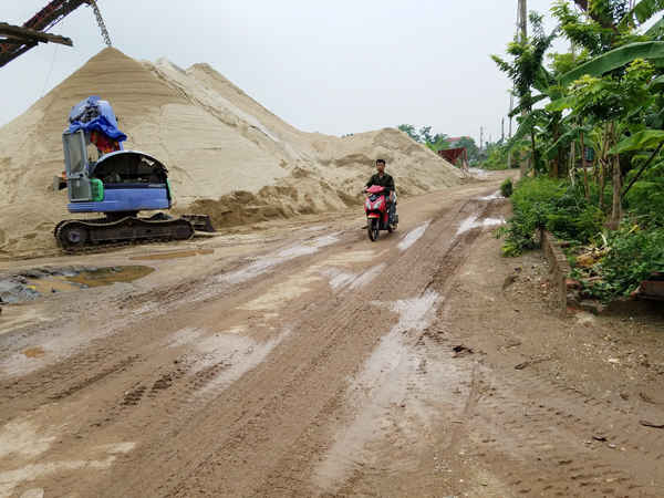 Nhiều bãi tập kết VLXD nằm sát mép sông, án ngữ trên trục đường giao thông thôn xóm