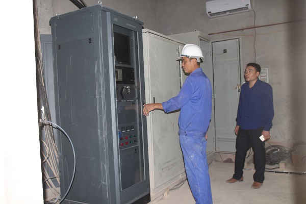 Công nhân nhà máy đang bảo dưỡng thiết bị quan trắc tự động để đi vào hoạt động