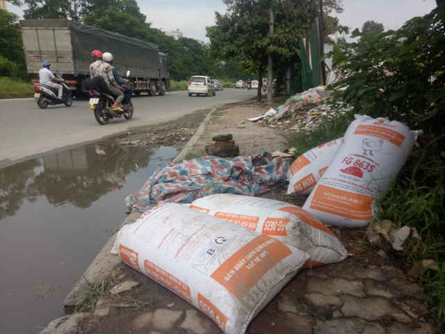 Các loại bao tải rác thải được vứt một cách hồn nhiên, vô tư ra vỉa hè đường gom Đại lộ Thăng Long