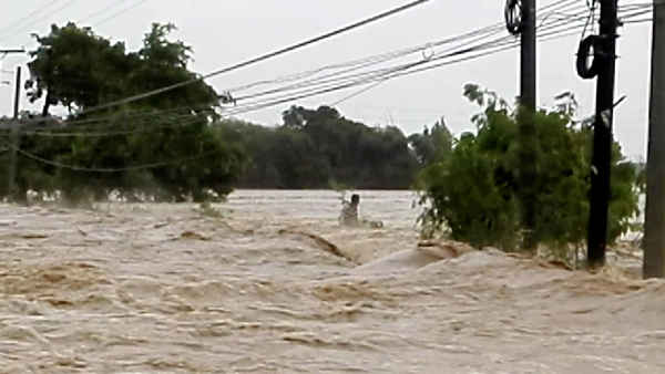 Một người đàn ông bị mắc kẹt trong dòng nước lũ dâng cao do siêu bão Mangkhut trước khi người này được giải cứu ở Tarlac, Philippines vào ngày 15/9/2018