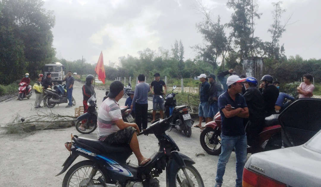 Người dân dùng cây cối, vật dụng chặn đường đi không cho xe bê tông của Công ty Cổ phần xây dựng và đầu tư thương mại Việt Hàn- CN Quảng Nam ra vào Cụm công nghiệp Nam Dương do gây ô nhiễm môi trường