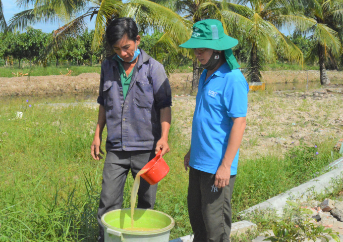 Anh Nguyễn Quốc Nam (bên phải) hướng dẫn hộ nông dân tạo ra vi sinh vật bản địa - IMO gốc, từ đó ứng dụng xử lý môi trường nuôi trồng thủy sản, ủ rác, cá tạp để tạo ra dung dịch phân phón hữu cơ để sản xuất nông nghiệp sạch. Ảnh: Trung Chánh.