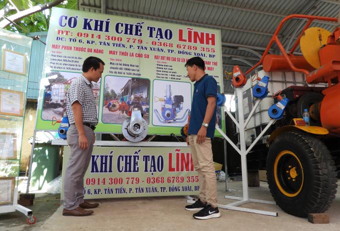 Anh Nguyễn Văn Lĩnh giới thiệu hệ thống bơm mủ cao su cho đối tác. Ảnh: Trần Trung.