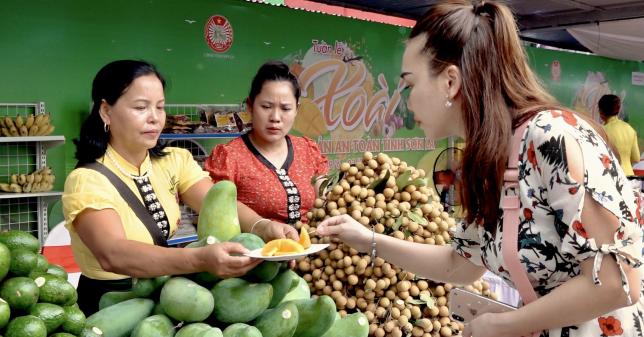 Khách hàng thưởng thức sản phẩm xoài Đài Loan tại gian hàng trưng bày sản phẩm nông sản tỉnh Sơn La tại Big C Thăng Long (Hà Nội). Ảnh: Thanh Thủy.