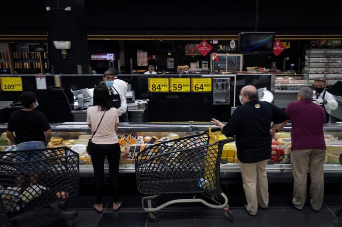 People shop at a supermarket in Beirut, Lebanon, Monday, July 15, 2022. In Lebanon, where endemic corruption and political stalemate has crippled the economy, the World Food Program is increasingly providing people with cash assistance to purchase food, particularly after the devastating 2020 port blast that destroyed massive grain silos. Photo: AP