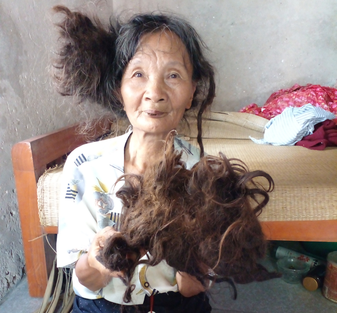 Bà Đỗ Thị Năm kể cho chúng tôi nghe về mái tóc kì dị của mình. Ảnh: Trần Toản.
