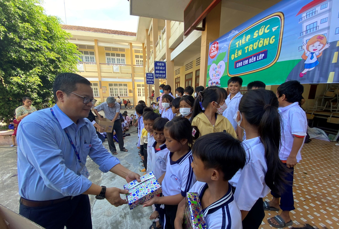 Các cháu học sinh phấn khởi nhận quà từ Co.opmart Quy Nhơn. Ảnh: V.Đ.T.