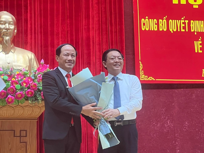 Tân Phó Bí thư Tỉnh ủy Bình Định Phạm Anh Tuấn (bìa trái) nhận hoa chúc mừng của Bí thư Tỉnh ủy Bình Định Hồ Quốc Dũng. Ảnh: V.Đ.T.