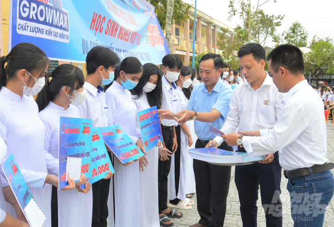 Ông Nguyễn Ngọc Thắng, Trưởng Văn phòng đại diện Báo Nông nghiệp Việt Nam khu vực ĐBSCL và ông Vũ Văn Toản đại diện Công ty TNHH Thức ăn Thủy sản GrowMax trao học bổng cho học sinh có hoàn cảnh khó khăn Trường THCS và THPT Vĩnh Bình Bắc. Ảnh: Trung Chánh.