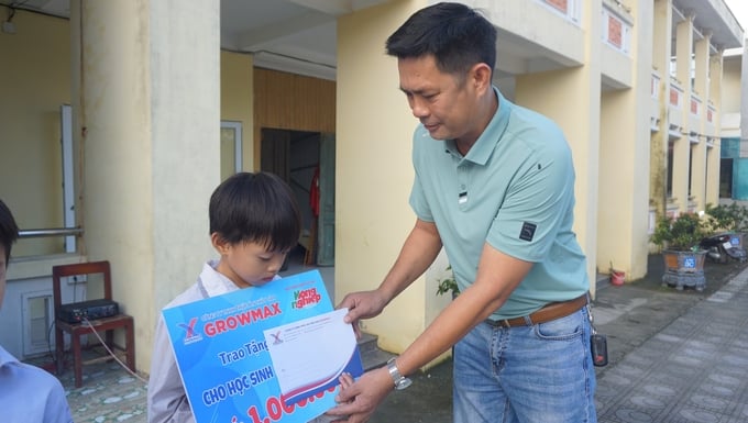 Ông Dương Văn Trường, đại diện nhà phân phối thức ăn thuỷ sản GrowMax tại Thị xã Nghi Sơn trao quà cho học sinh nghèo tại Trường tiểu học Hải Thanh A.