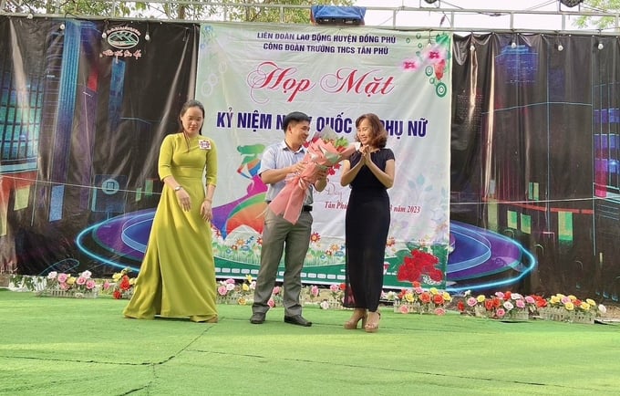 Thầy Mai Đức Dân, Bí thư Chi bộ, Hiệu trưởng nhà trường tặng hoa chúc mừng tập thể giáo viên nữ nhân ngày 8/3. Ảnh: Hải Yến.