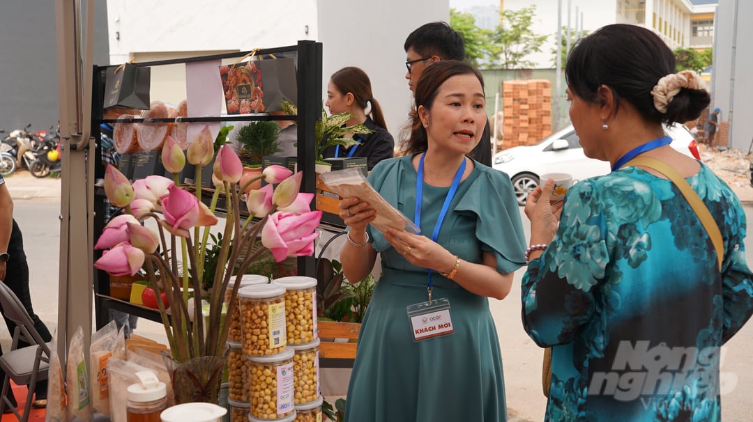 Chị Nguyễn Thị Bích Lệ, Giám đốc HTX Dịch vụ nông nghiệp Trường Phát (ấp Vĩnh Tiên, xã Long Tân, Nhơn Trạch, Đồng Nai) giới thiệu sản phẩm từ sen với khách hàng. Ảnh: Nguyễn Thủy.