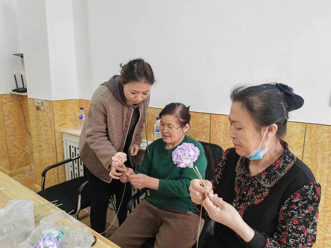Two female farmers (right) learn knitting skills in a studio in Shulan, Jilin province. Photo: Chinadaily.com