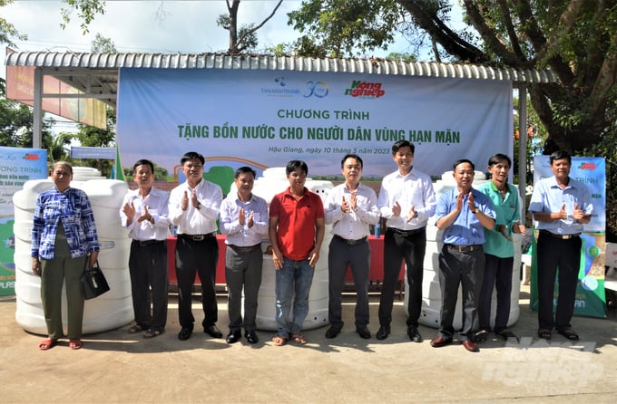 Các đại biểu trực tiếp trao tặng bồn cho bà con vùng hạn mặn. Ảnh: Trung Chánh.