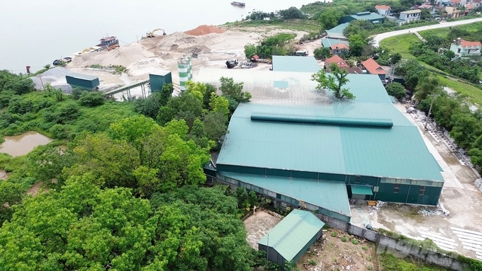 Trạm trộn bê tông không phép của Công ty TNHH thương mại và xây dựng Trung Sơn (Công ty Trung Sơn) nằm ngay trong hành lang bảo vệ đê điều đi qua xã Hồng Vân. Ảnh: Huy Bình.