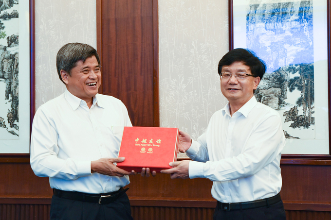 Deputy Minister Tran Thanh Nam and Vice Chairman of Yunnan province Duong Ban exchanging souvenirs at the meeting. Photo: Cao Tran.