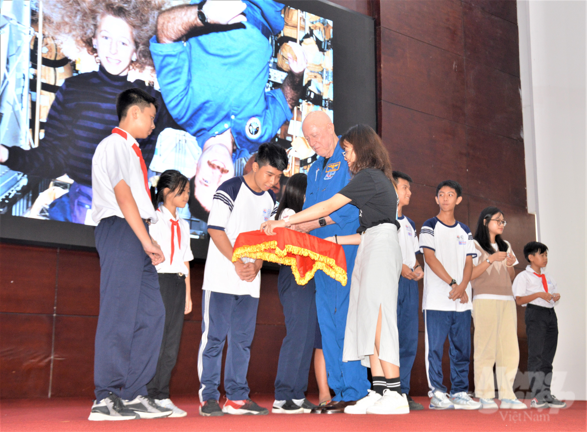 Former NASA astronaut Michael Baker hands out gifts to the students winning a game about space science. Photo: Trung Chanh.