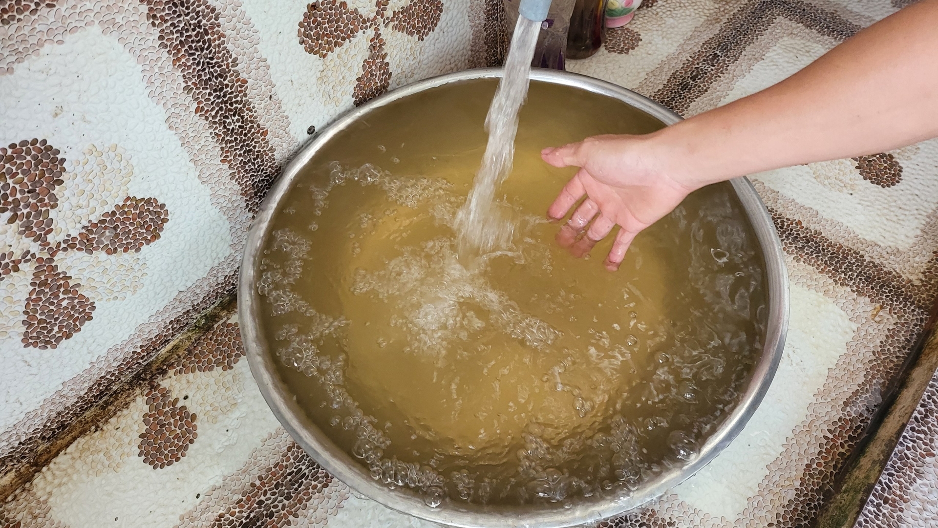 Nước cấp về cho nhà anh Hiệp bị đục, vàng. Ảnh: Đăng Lâm.