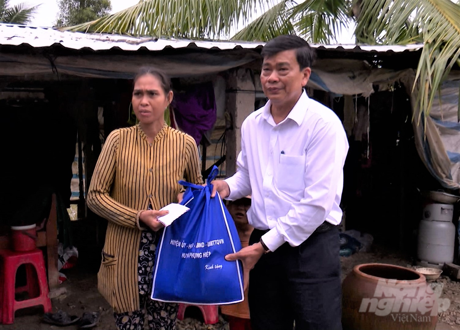 Đại diện chính quyền địa phương ở tỉnh Hậu Giang thăm hỏi, hỗ trợ các hộ gia đình có nhà bị sập và tốc mái. Ảnh: Trung Chánh.