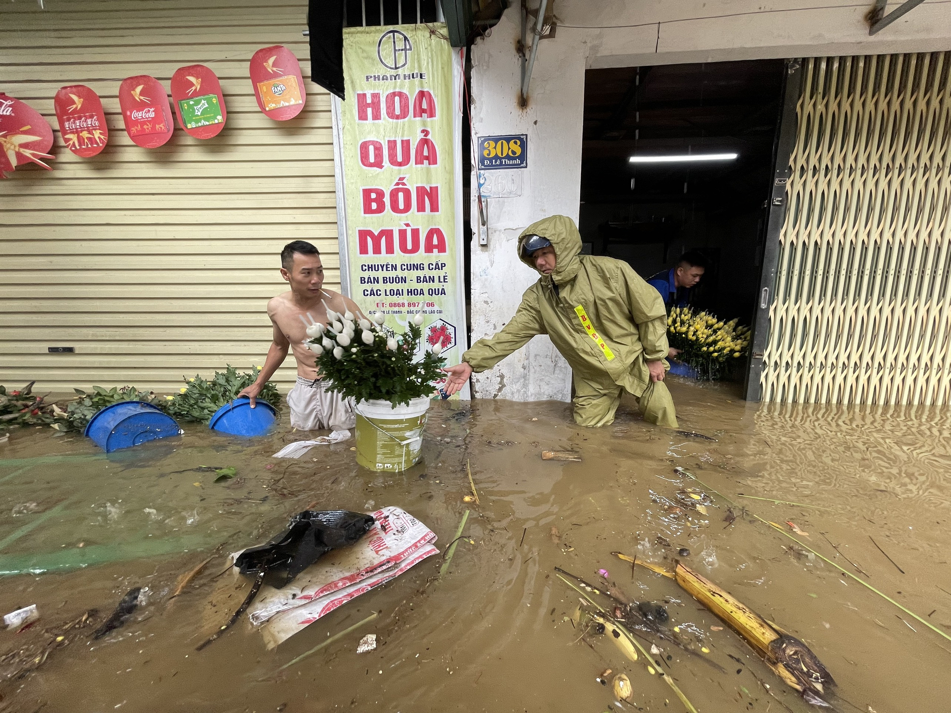 z4561875960769_36238056267138ecc124496f3f5bba45-114550_271.jpg Cửa hàng bán hoa di chuyển những thùng hoa cúc ra ngoài để cứu vãn thiệt hại dưới sự hỗ trợ của lực lượng chức năng.