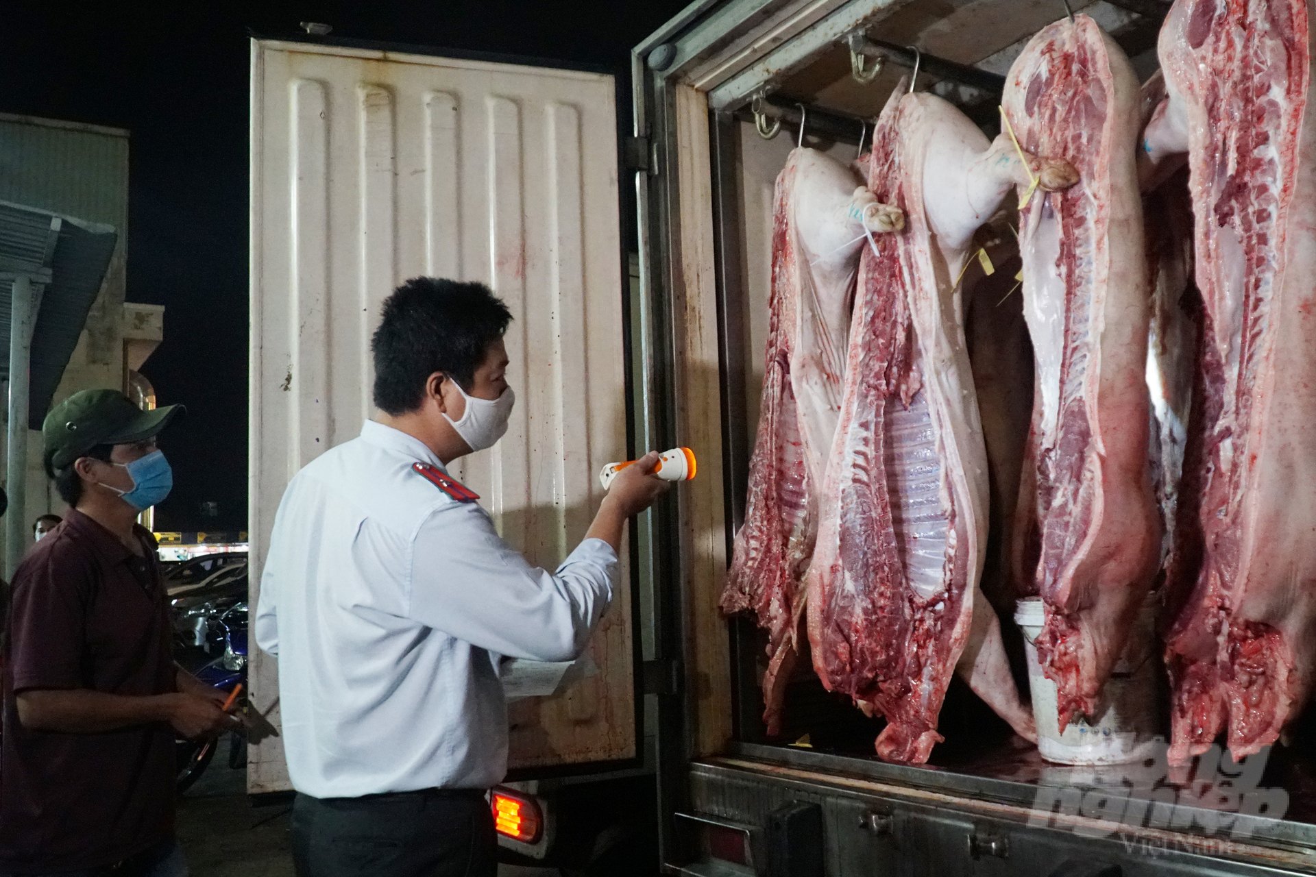 Functional forces control pork before being sold at Binh Dien wholesale market. Photo: Nguyen Thuy.