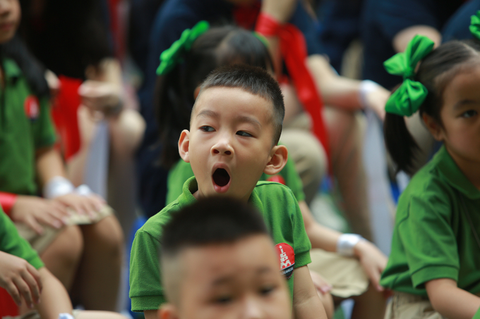 Hình ảnh dễ thương của các em nhỏ vào lớp 1 vừa cổ vũ văn nghệ vừa ngáp. Ảnh: Hùng Khang.