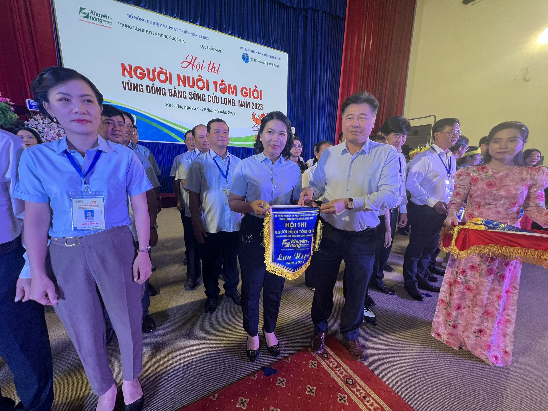 z4737736535629_7e8f655538ad248a6b4cb4a14e1ad818-144429_152.jpg Ông Lê Quốc Thanh, Giám đốc Trung tâm Khuyến nông Quốc gia, Trưởng Ban tổ chức Hội thi 'Người nuôi tôm giỏi vùng ĐBSCL năm 2023' tặng cờ lưu niệm cho các đội thi. Ảnh: Trọng Linh.