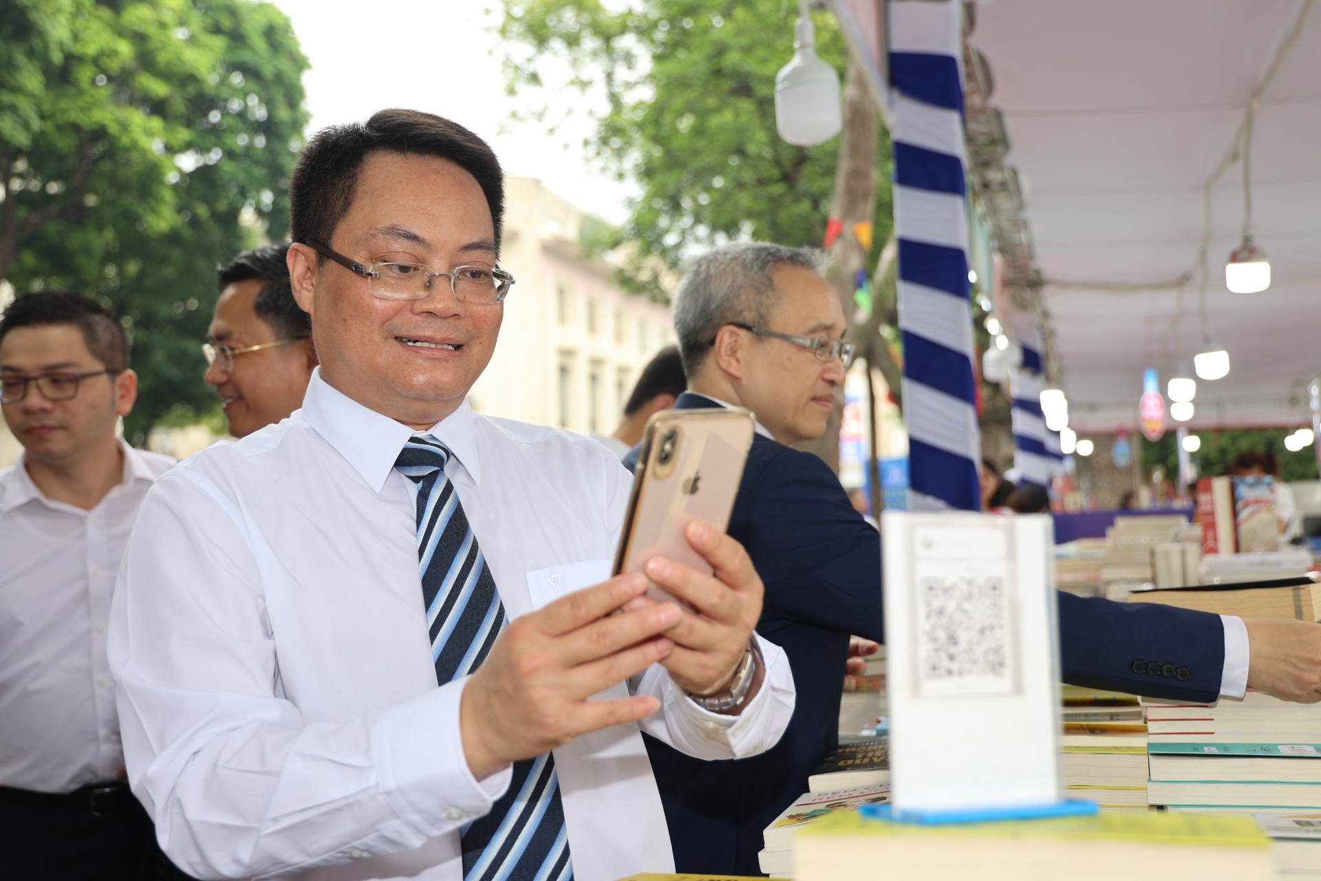 Giám đốc Sở TT-TT Hà Nội Nguyễn Việt Hùng trải nghiệm dịch vụ thanh toán không dùng tiền mặt tại phố đi bộ Hoàn Kiếm. 