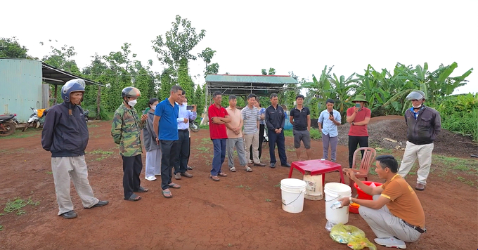 Ông Hà Công Xã (ngồi) hướng dẫn xã viên cách pha chế chế phẩm phòng trừ sâu sinh học. Ảnh: Hồng Thủy.
