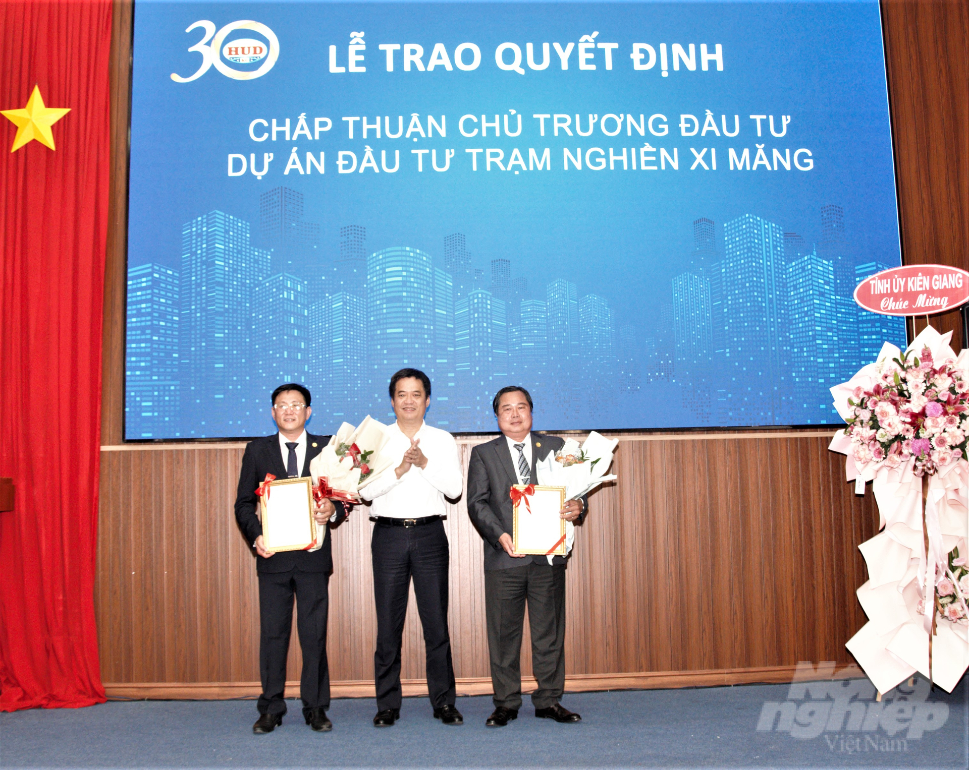 Phó Chủ tịch UBND tỉnh Kiên Giang Lê Quốc Anh (đứng giữa) trao quyết định chấp nhận chủ trương đầu dự án đầu tư trạm nghiền xi măng cho Công ty CP Đầu tư Xây dựng HUD Kiên Giang. Ảnh: Trung Chánh.