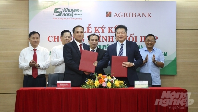 Ông Lê Quốc Thanh, giám đốc Trung tâm Khuyến nông Quốc gia (thứ 2 từ phải sang) và ông Lê Hồng Phúc, Phó Tổng Giám đốc Agribank ký kết chương trình phối hợp. Ảnh: Lâm Hùng.
