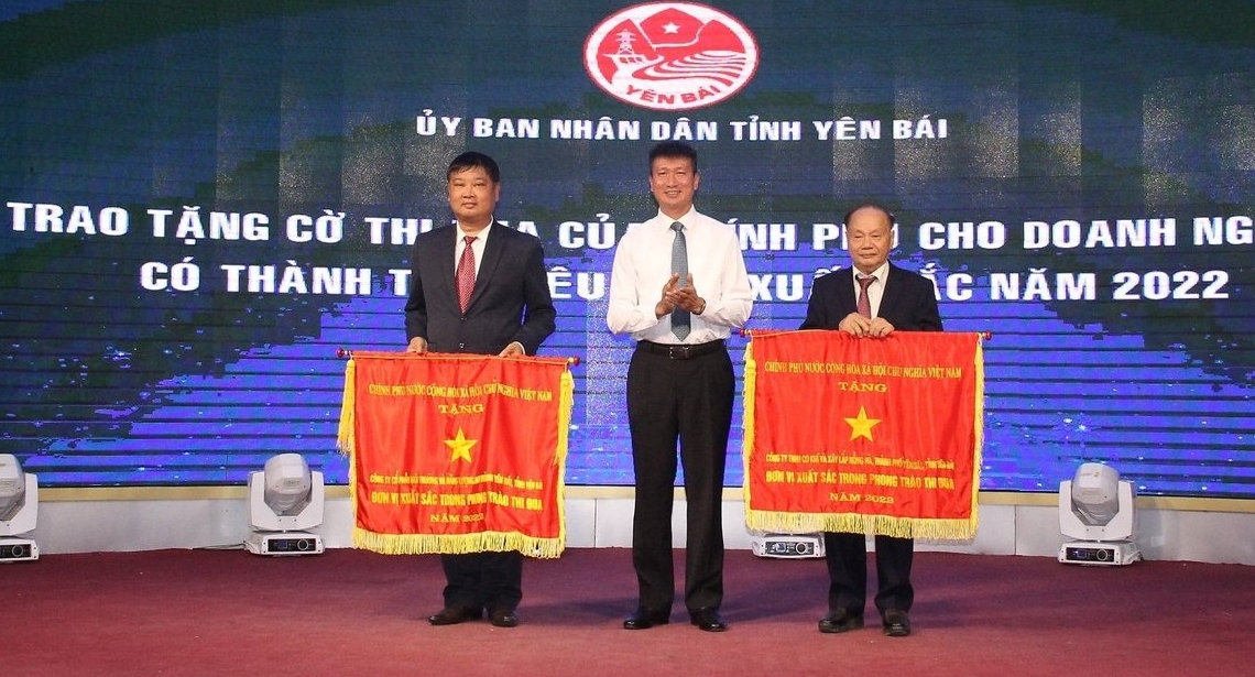 Chủ tịch UBND tỉnh Yên Bái trao cờ thi đua của Thủ tướng Chính phủ cho 2 tập thể có thành tích xuất sắc. Ảnh: Thanh Tiến.