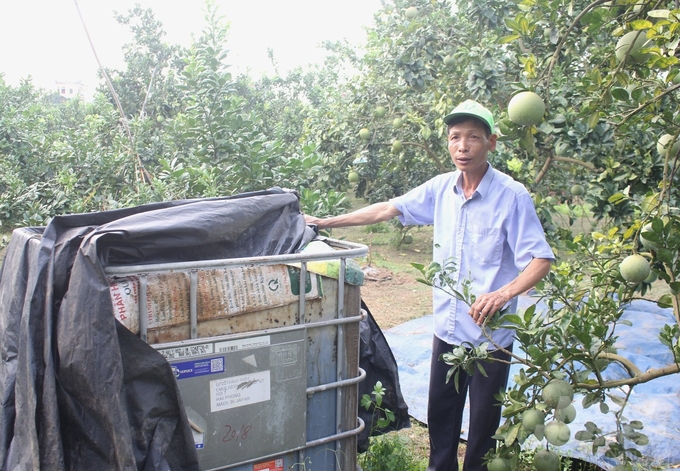 Ông Én ngâm ủ cá, đậu tương để bón cho cây thay thế phân bón hóa học. Ảnh: Trung Quân.
